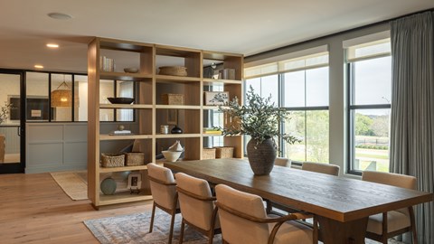 A dining room with a wooden table and chairs.